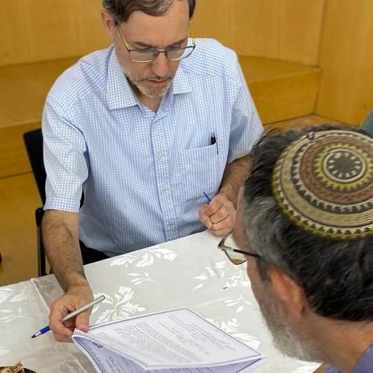 Rabbi signing halachic postnup